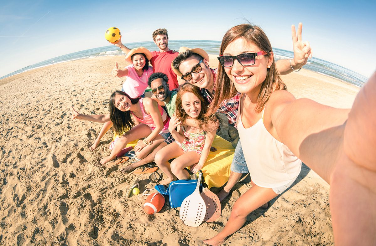 Photo of happy friends taking selfie and having fun with beach sport games