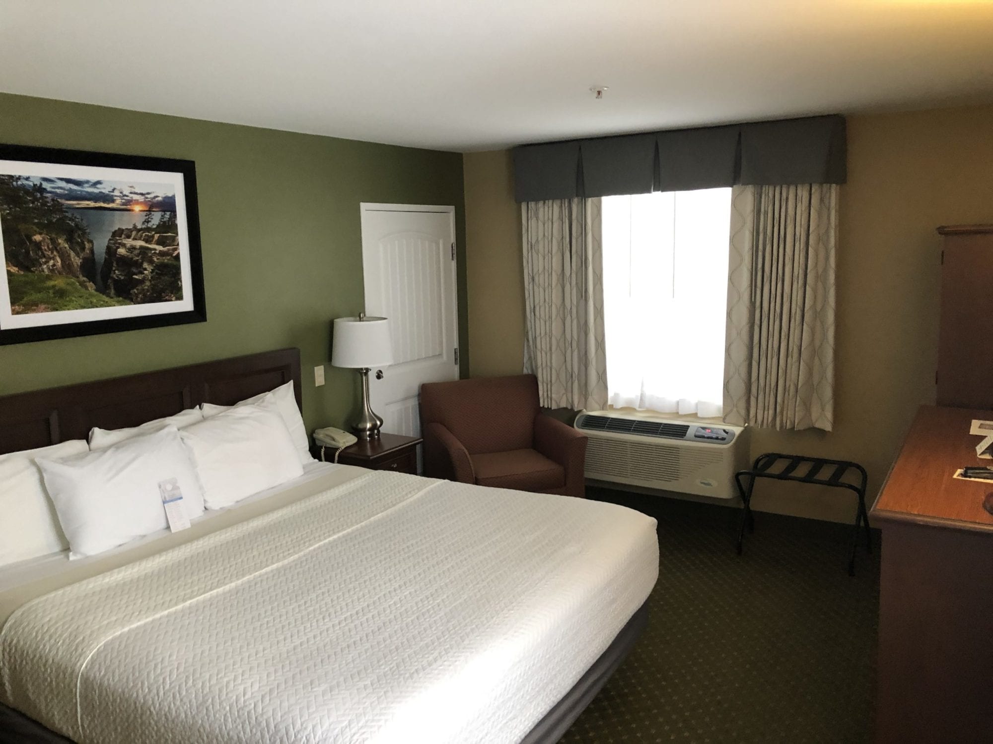Photo of the bedroom of the Accessible King room with roll-in shower at the Acadia Inn.