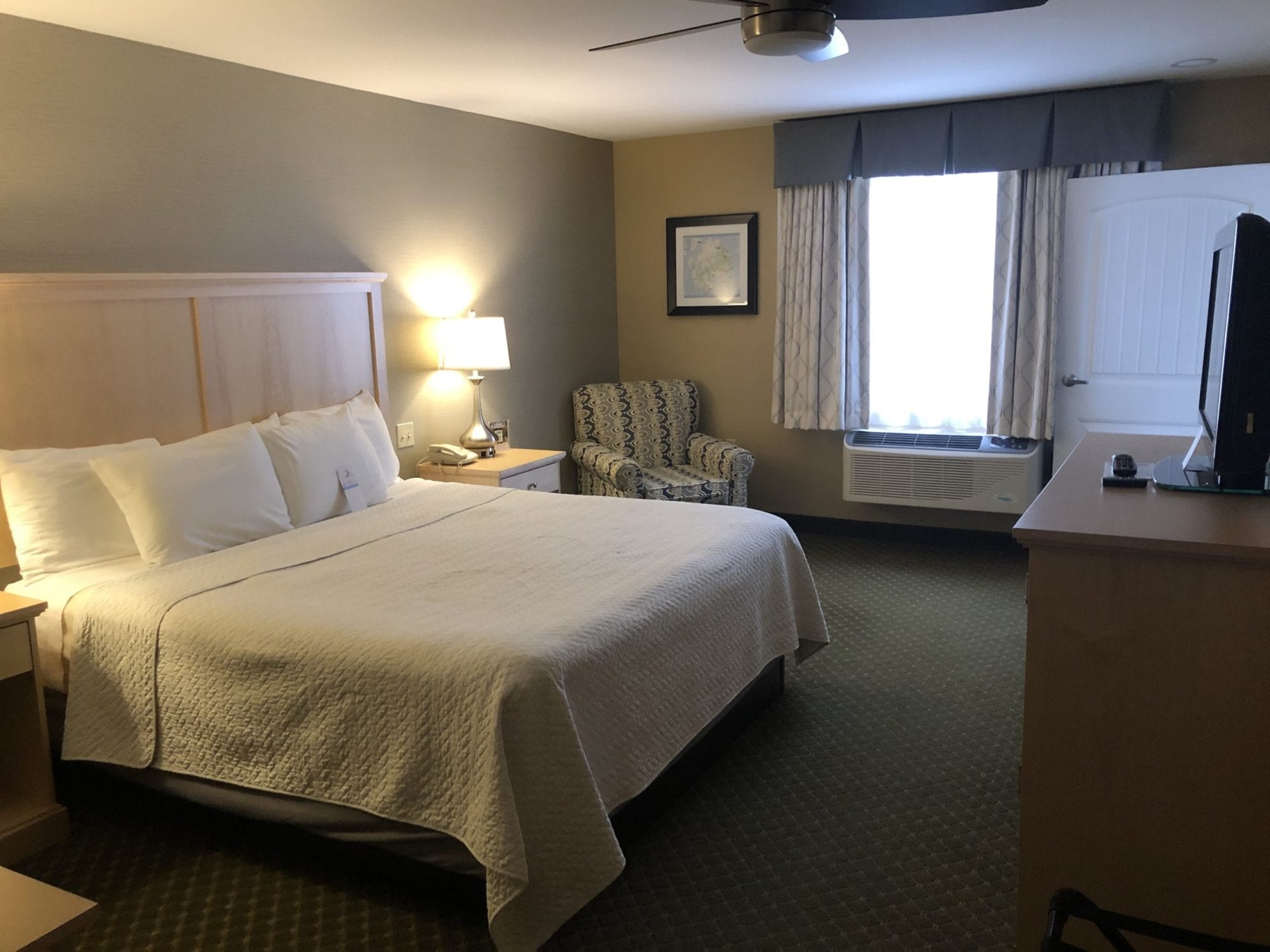 Photo of the bedroom of the Accessible King Suite at the Acadia Inn.