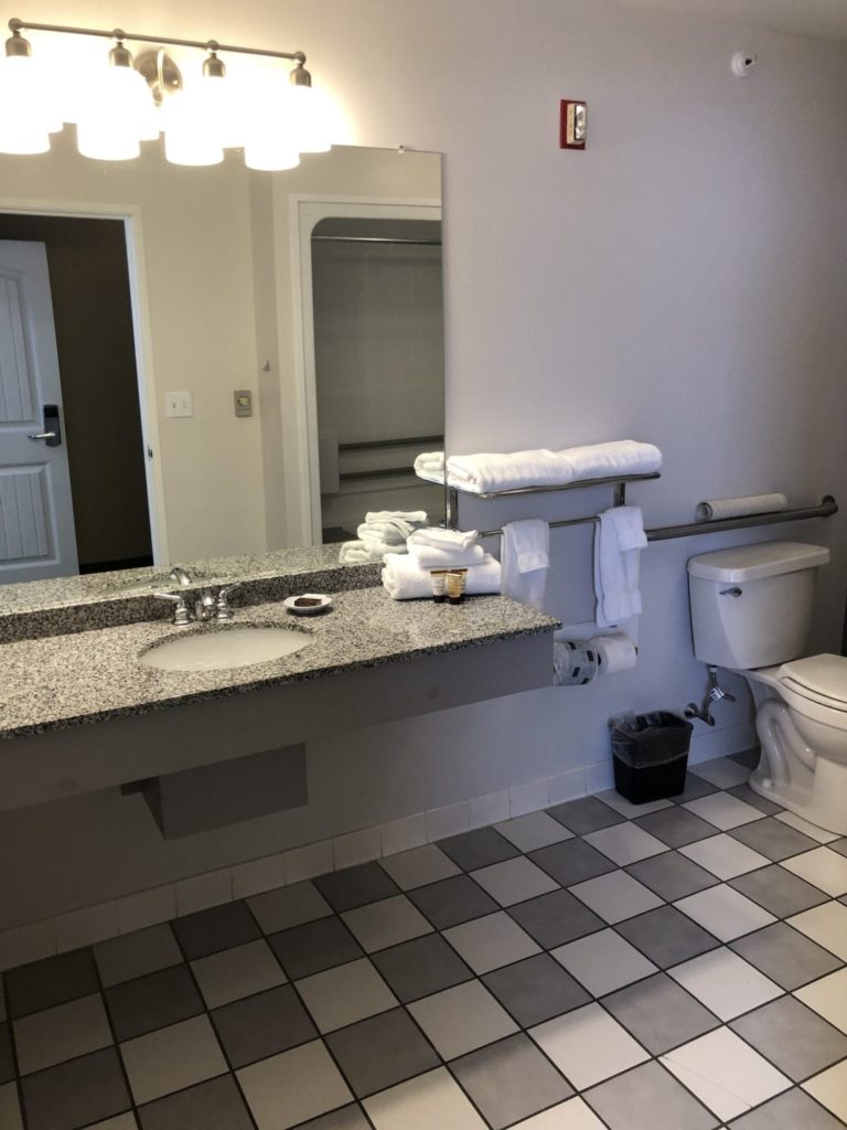 Photo of the bathroom of the Accessible King room with roll-in shower at the Acadia Inn.