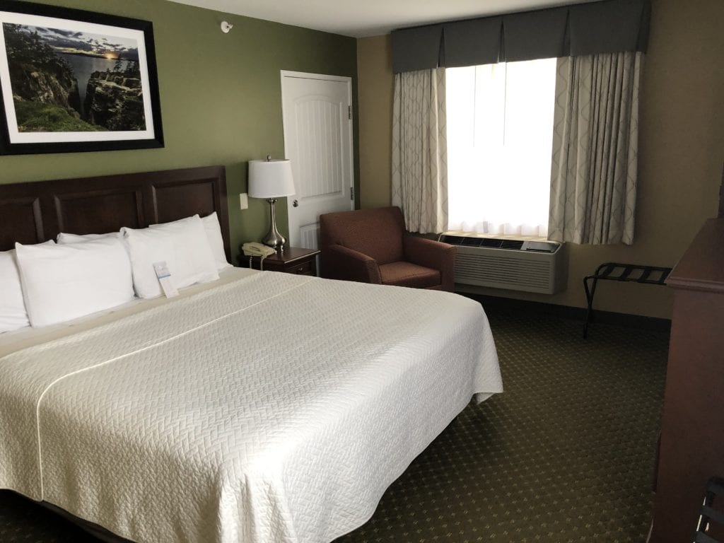 Photo of the bedroom of the Accessible King room with roll-in shower at the Acadia Inn.